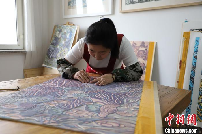 图为王秀春在刻制版画。 张林虎 摄 图为王秀春在刻制版画。 张林虎 摄